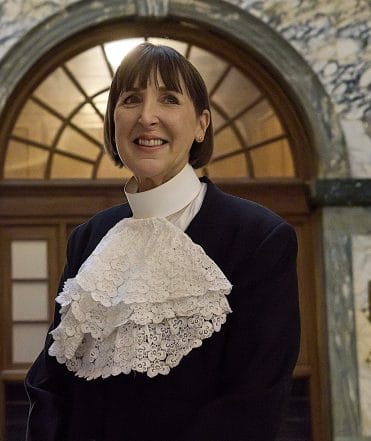 Fiona in a formal city of London livery company dress, a black jacket and white jabot collar.